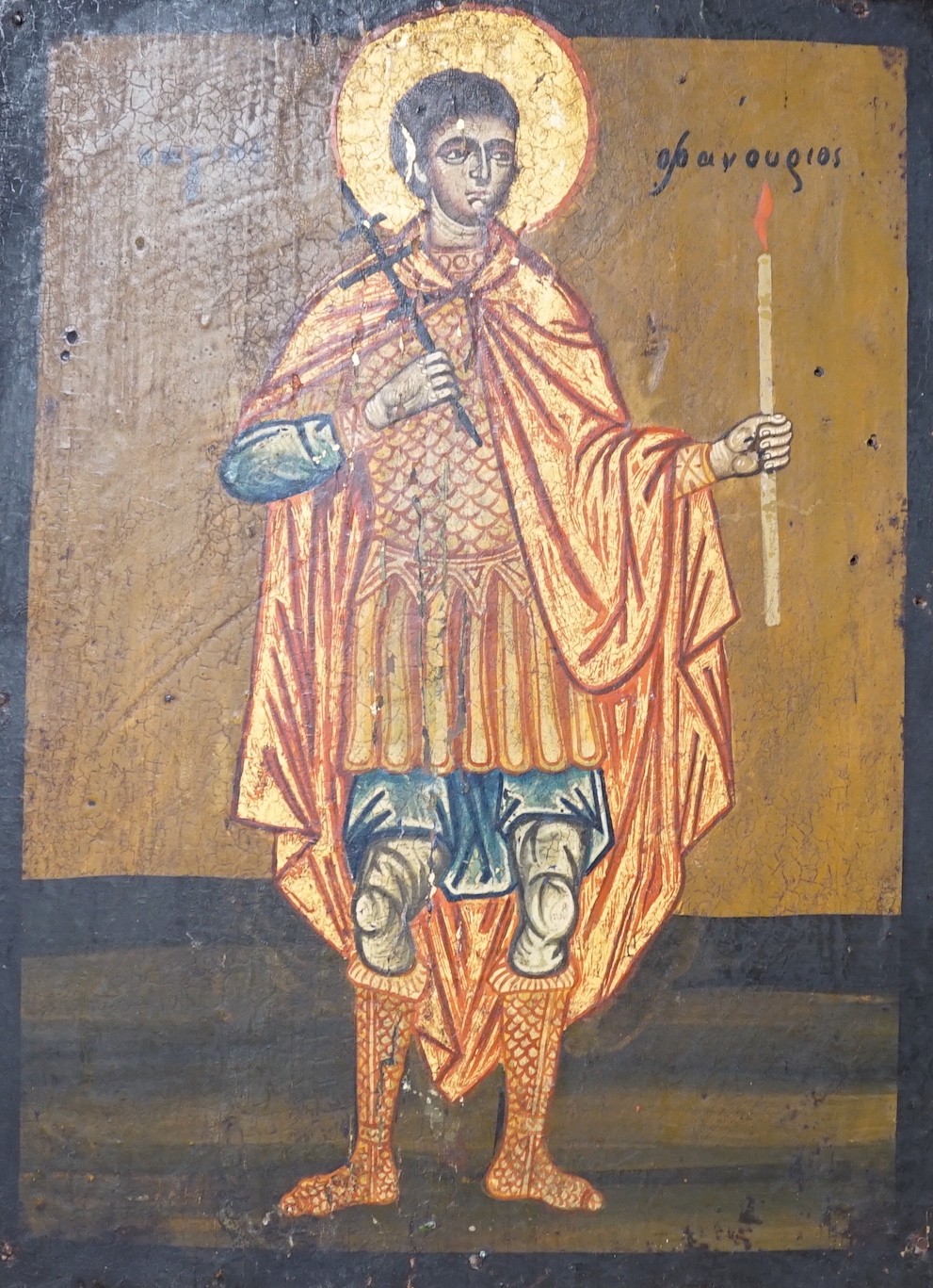 Greek School, tempera on wooden panel, Icon of a standing saint holding a candle, 33 x 24.5cm